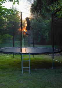 a person is jumping on a trampoline at Siedlisko Otulenie in Bartoszyce