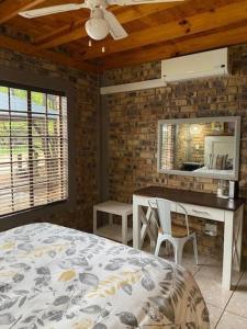 a bedroom with a bed and a table and a mirror at Kudu's Rus in Marloth Park in Marloth Park