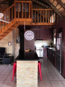 a large kitchen with a clock on the wall at Kudu's Rus in Marloth Park in Marloth Park
