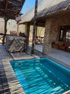 a blue swimming pool in front of a building at Kudu's Rus in Marloth Park in Marloth Park