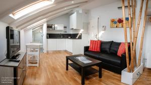 een woonkamer met een zwarte bank en een tafel bij Living4Malaga Calderón de la Barca in Málaga