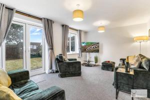 ein Wohnzimmer mit zwei Sofas und einem Fernseher in der Unterkunft Modern 4-Bedroom Gem Family & Business Friendly in Coalville