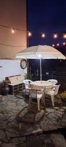 - une table et des chaises avec un parasol sur la terrasse dans l'établissement La casetta della nonna, à Caprese Michelangelo