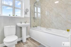 ein weißes Badezimmer mit Toilette und Waschbecken in der Unterkunft Modern 4-Bedroom Gem Family & Business Friendly in Coalville + 26 Fotos