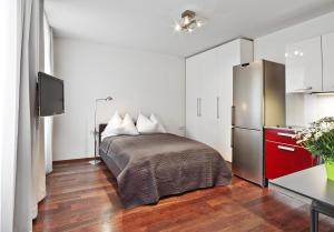 a bedroom with a bed and a refrigerator at Schlossquadrat Apartement 15 in Vienna