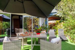 un patio con mesa, sillas y sombrilla en Dolce Vita en La Ciotat