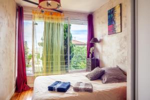 a bedroom with a bed and a large window at Dolce Vita in La Ciotat