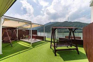 - une terrasse couverte avec des chaises et une balançoire sur un bateau dans l'établissement The Amber Hotel, à Yangpyeong