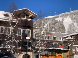 a building with a snow covered mountain in the background at Åre Travel - Mitt i Åre 2 in Åre