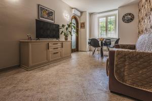 a living room with a television and a dining room at Casa Dolce Casa in Orvieto