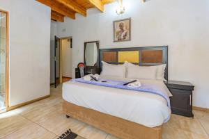 1 dormitorio con 1 cama grande en una habitación en Royal Olympia Lodges & Safaris RSA, en Sandton