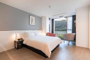 a hotel room with a bed and a table and chairs at The Amber Hotel in Yangpyeong