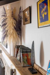 une étagère avec des livres et une plume sur elle dans l'établissement Gîte Le Carpe diem Milly-la-Forêt, à Milly-la-Forêt