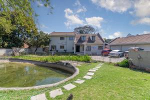 a house with a pond in the yard at Royal Olympia Lodges & Safaris RSA in Sandton