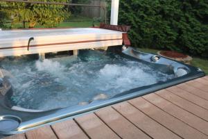 a hot tub with a bench on a deck at Arlington, VA for Lovers and Friends in Arlington