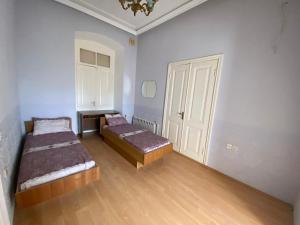 a room with two beds and a door in it at Beaming_House in Sheki