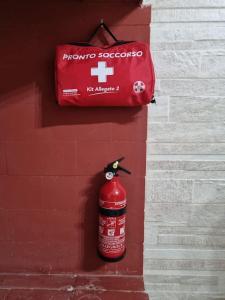 un idrante rosso appeso a un muro di Villa M&P - Il Trullo - a Casalabate