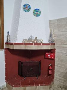 einen Kamin mit einem roten Kaminsims mit Platten drauf in der Unterkunft Villa M&P - Il Trullo - in Casalabate