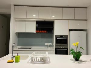 a kitchen with white cabinets and a white counter top at KLCC Ritz Residence Platinum in Kuala Lumpur