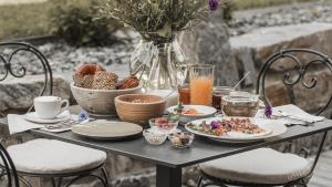 a table with breakfast foods and a vase of flowers at ASTER Boutique Hotel & Chalets in Fügenberg
