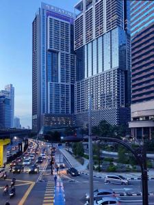ruchliwa ulica miejska z korkiem przed wysokimi budynkami w obiekcie KLCC Ritz Residence Platinum w Kuala Lumpur