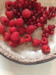 Un pastel con fresas y frambuesas sobre una mesa. en Maison d'Artiste, en Gante