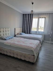 sypialnia z 2 łóżkami i oknem w obiekcie Denize yakın kiralık daire 3+1 / 140m² w mieście Arsin