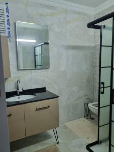 W łazience znajduje się umywalka, lustro i toaleta. w obiekcie Denize yakın kiralık daire 3+1 / 140m² w mieście Arsin