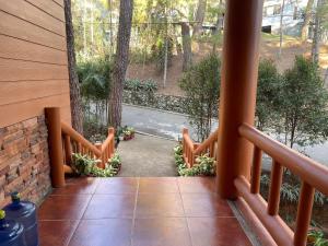 an open door to a porch with a fence at Country Homes Sheridan Drive Camp John Hay Lot 16 in Baguio