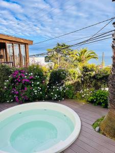 una bañera de hidromasaje en una terraza con flores en Blumen Hotel, en Concón