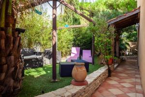 d'une terrasse avec des chaises et un vase dans la cour. dans l'établissement Villa kitesurf 350m plage de sable, à Six-Fours-les-Plages