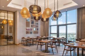 a restaurant with tables and chairs and large windows at Paramount Hotel Apartment Midtown - Platinium Dubai in Dubai