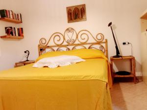 1 dormitorio con 1 cama con colcha amarilla en Pinna1 - Appartamento in villetta in pineta - IUN R4823, en S'Archittu