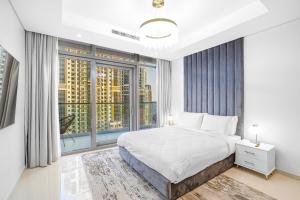 a bedroom with a large bed and a large window at Paramount Hotel Apartment Midtown - Platinium Dubai in Dubai