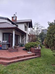 a house with a brick patio in the yard at zielone Bemowo zaprasza in Warsaw