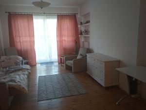 a bedroom with a bed and a dresser and a window at zielone Bemowo zaprasza in Warsaw