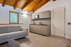 een woonkamer met een bank en een keuken bij Appartamento Midum Domus Attic in Trento