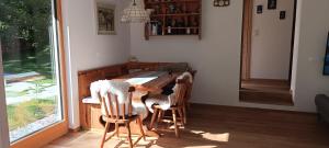 a kitchen with a wooden table with chairs and a window at House Apartma Čebela with jacuzzi in Gozd Martuljek