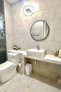 a bathroom with a sink toilet and a mirror at The Shore 12, Kota Kinabalu by HypnosSuites in Kota Kinabalu