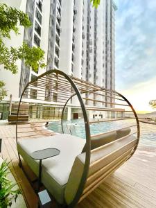 a bench in front of a pool in a city at The Shore 12, Kota Kinabalu by HypnosSuites in Kota Kinabalu