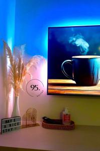 a coffee cup sitting on a shelf next to a painting at The Shore 12, Kota Kinabalu by HypnosSuites in Kota Kinabalu