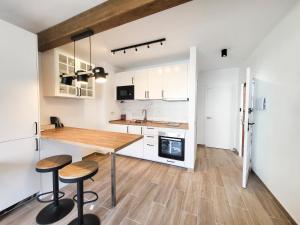 a kitchen with a wooden table and two stools at NEWQUAY in Playa de las Americas