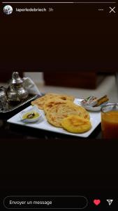 un plato de comida con panqueques en una mesa en La Perle De Briech en Asilah