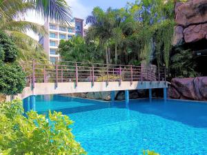 a bridge over a swimming pool with blue water at Laguna Beach Resort 3 Maldives in Jomtien Beach