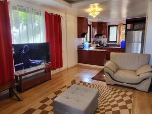 a living room with a couch and a flat screen tv at Country Homes Sheridan Drive Camp John Hay Lot 16 in Baguio
