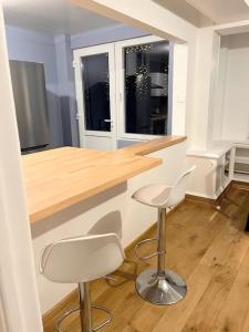 a kitchen with a counter and two bar stools at Superbe appartement aéroport et gare Charleroi in Charleroi