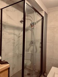 a shower with a glass door in a bathroom at Superbe appartement aéroport et gare Charleroi in Charleroi