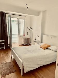 a bedroom with a large white bed in a room at Superbe appartement aéroport et gare Charleroi in Charleroi