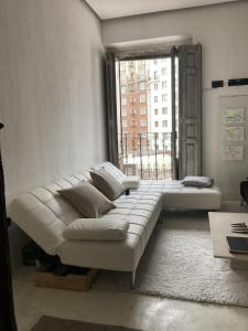 een grote witte bank in een kamer met een raam bij Captivating 2-Bed Apartment in Madrid in Madrid