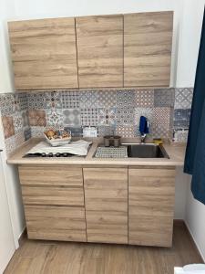 eine Küche mit Holzschränken und einem Waschbecken in der Unterkunft Trulli bella vite in Putignano